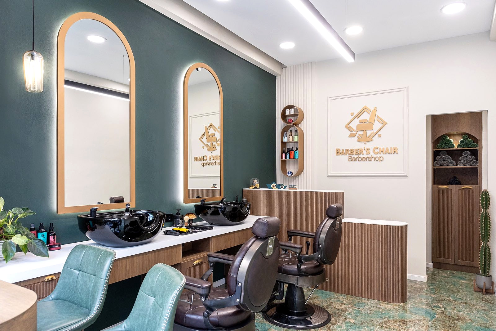 Το εσωτερικό του Barber's Chair: πράσινος τοίχος, δύο καθρέφτες σε καμάρα με μπρούτζινο πλαίσιο, δερμάτινες καρέκλες και πράσινο μαρμάρινο δάπεδο